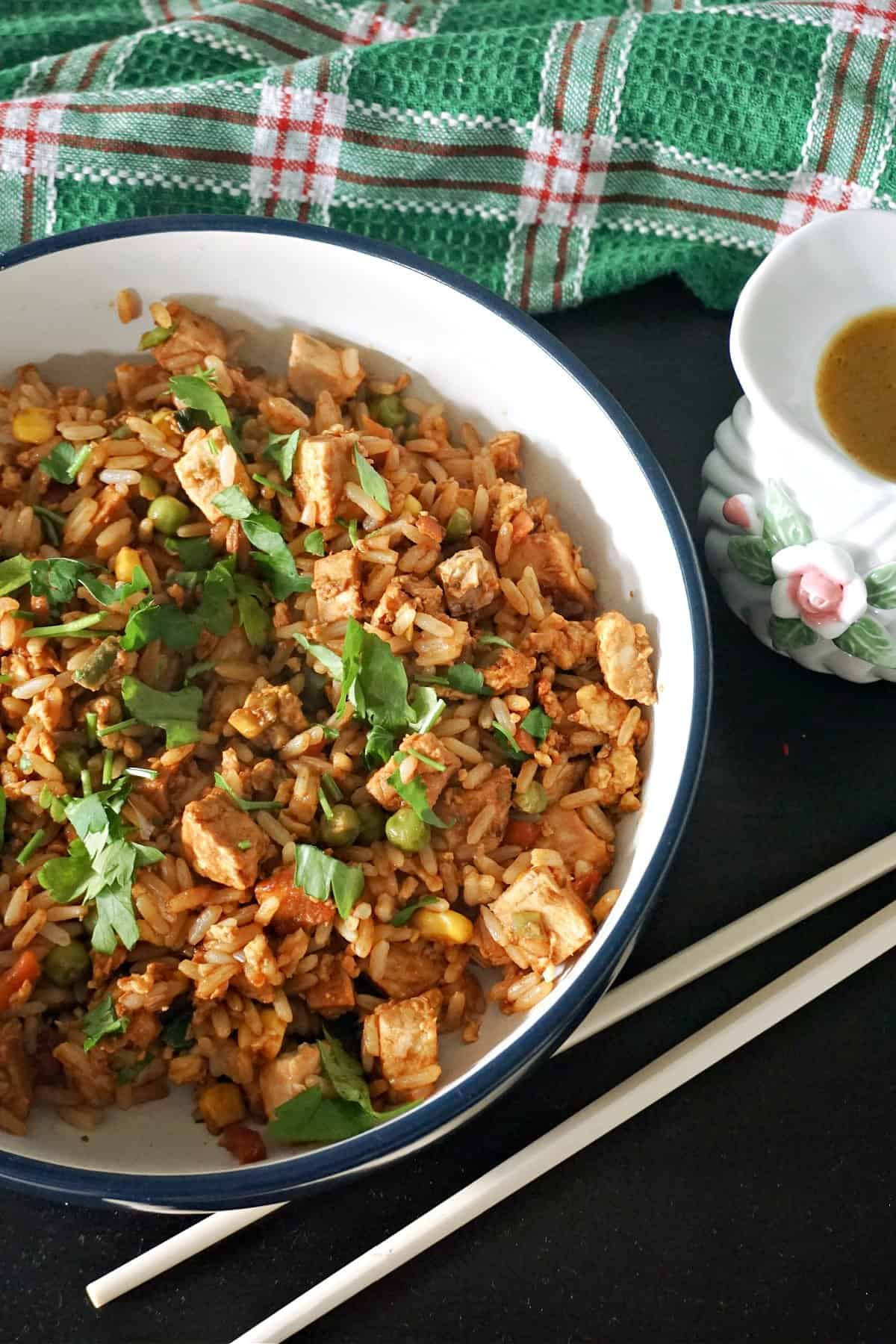 A bowl with egg fried rice garnished with fresh parsley.