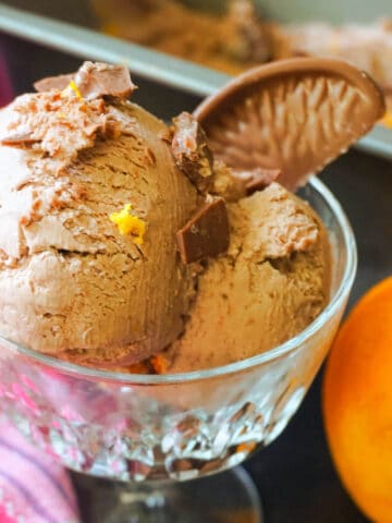 A glass with chocolate orange ice cream with a segment of Terry' chocolate orange.