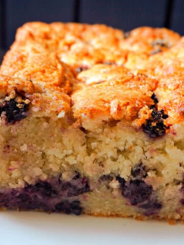 A sliced blackberry cake loaf on a white plate.