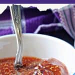 A white ramekin with fig jam and a fork into the jam, with a purple towel in the background.