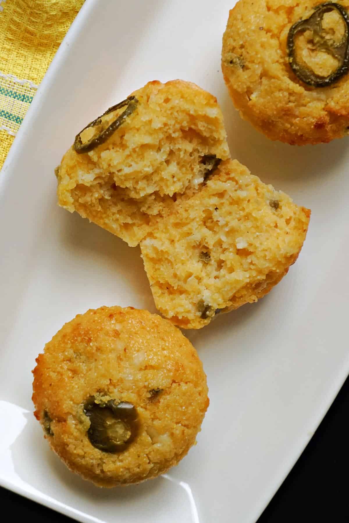 2 cornbread muffins with another muffin sliced in half.