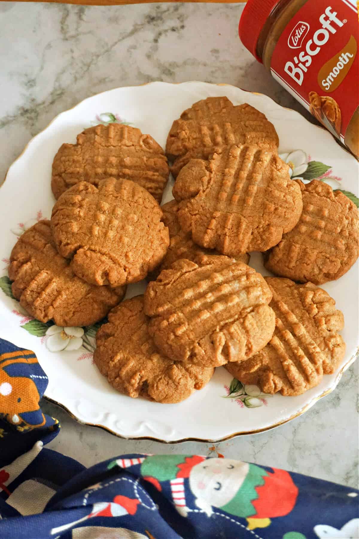 A white plate with biscoff cookies on a white background and a partially visible Lotus biscoff jar next to it.
