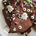 Shards of Halloween chocolate bark on a white plate with light blue rim.