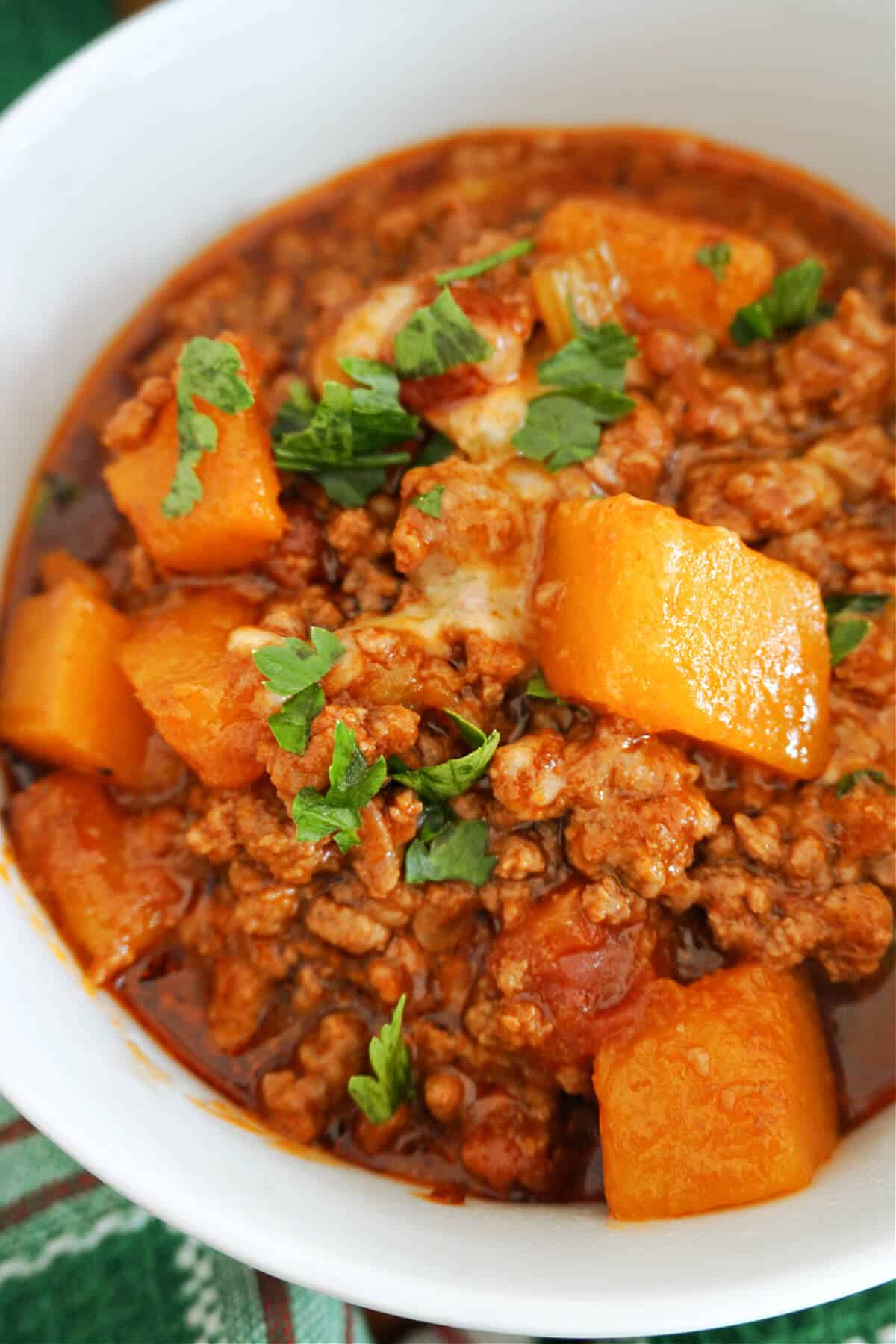 A white bowl with a portion of pumpkin chili.