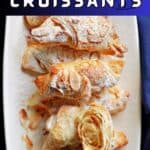 A white rectangle plate with almond croissants.