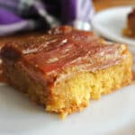 A slice of a rhubarb upside down cake on a white plate.