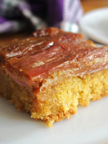 A slice of a rhubarb upside down cake on a white plate.