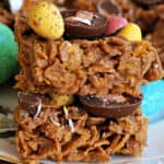 A stack of 2 chocolate cornflake squares topped with mini chocolates.