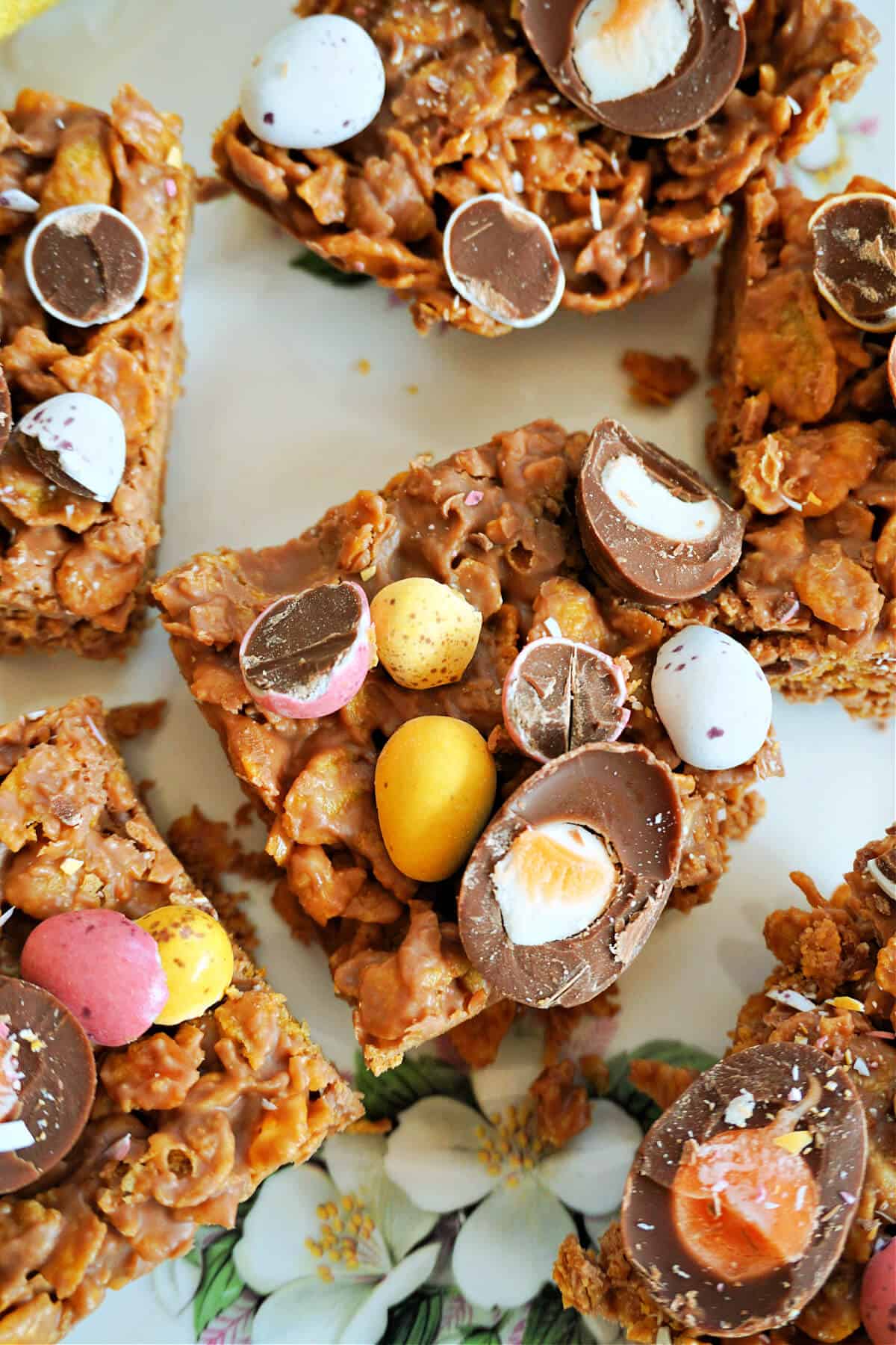 A chocolate square toppd with crushed mini eggs and halves of mini creme eggs and other 5 squares partially visible around the edges.
