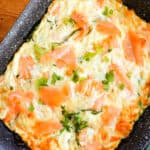 A roasting tray with frittata topped with chopped parsley and smoked salmon.