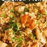 Close-up to a portion of chicken and rice garnished with chopped parsley.