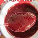 A white ramekin with berry ham and a spoon in it.
