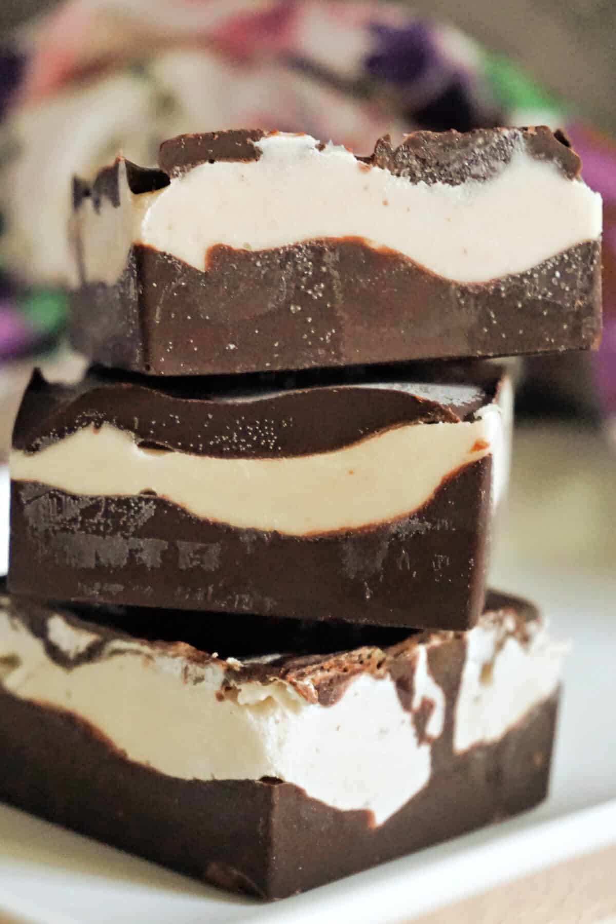 A stack of 3 ice cream bars on a white plate.
