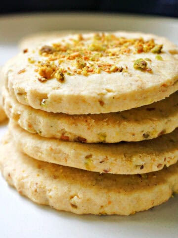 A stack of 4 cookies on a white plate.