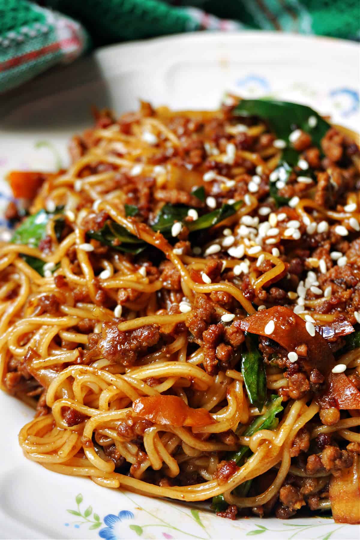 A white plate with a portion of noodle stir fry.