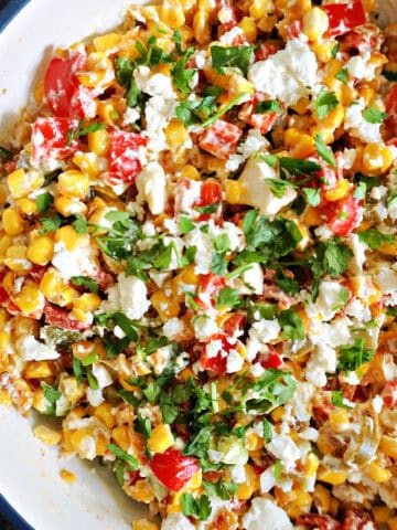 A white bowl with corn salad.