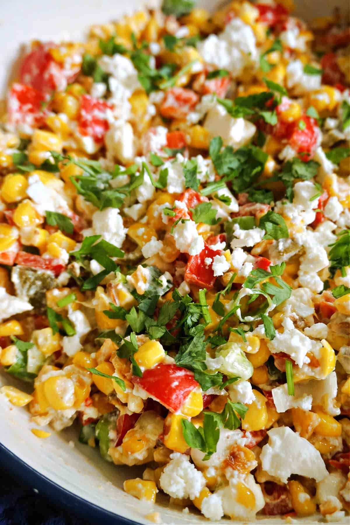 Close-up of a corn salad in a white bowl.
