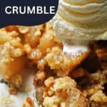Close-up of a portion of pear crumble on a plate with a partially visible scoop of ice cream on top.