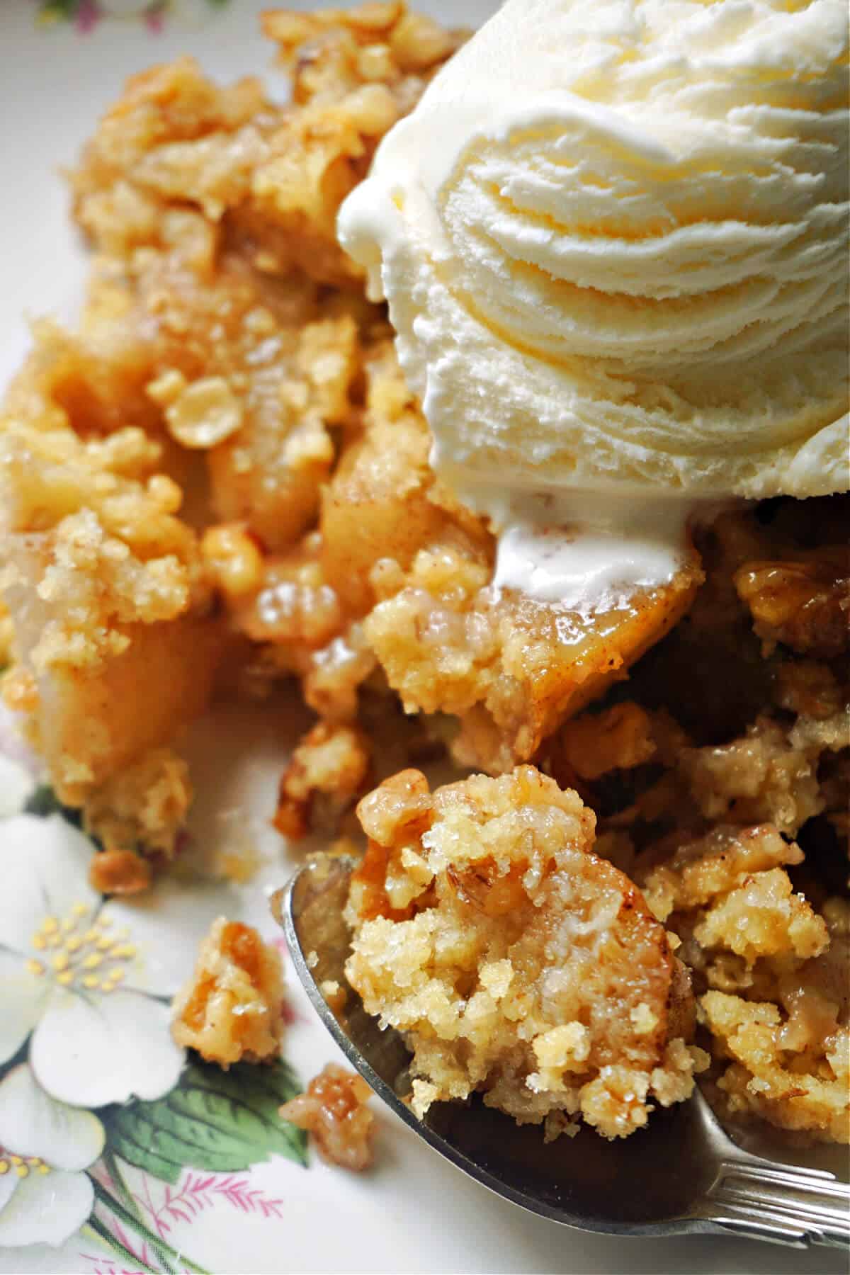 Close-up of pear crumble with a scoop of ice cream on top.