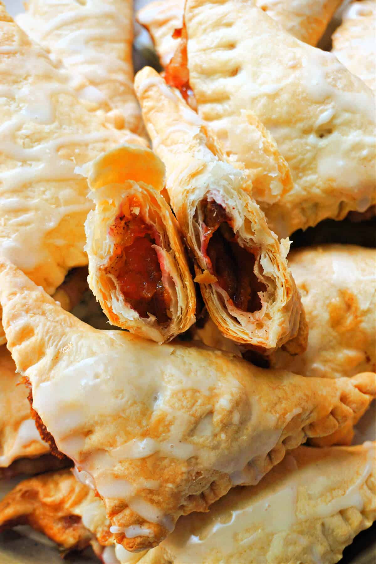 2 halves of a turnover on top of other puff pastry turnovers.