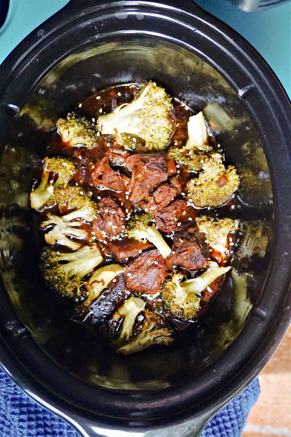 A slow cooker with beef and broccoli.