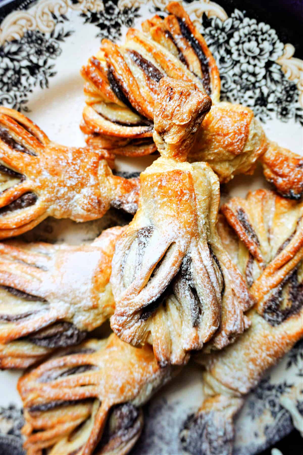 A Halloween-patterned plate with puff pastry and nutella brooms.