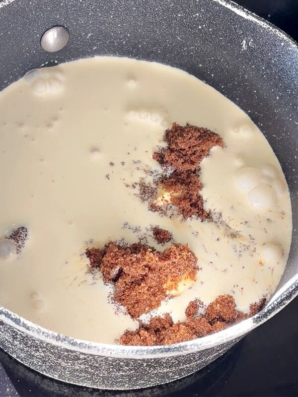 A pan with cream and dark brown sugar.