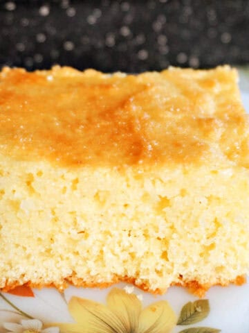 A slice of sponge cake on a white flowery plate.