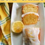 A white rectangle plate with half a lemon, 2 slices of lemon cake and the rst of the iced cake garnished with lemon zest. A yellow-pattered tea towel around the plate.