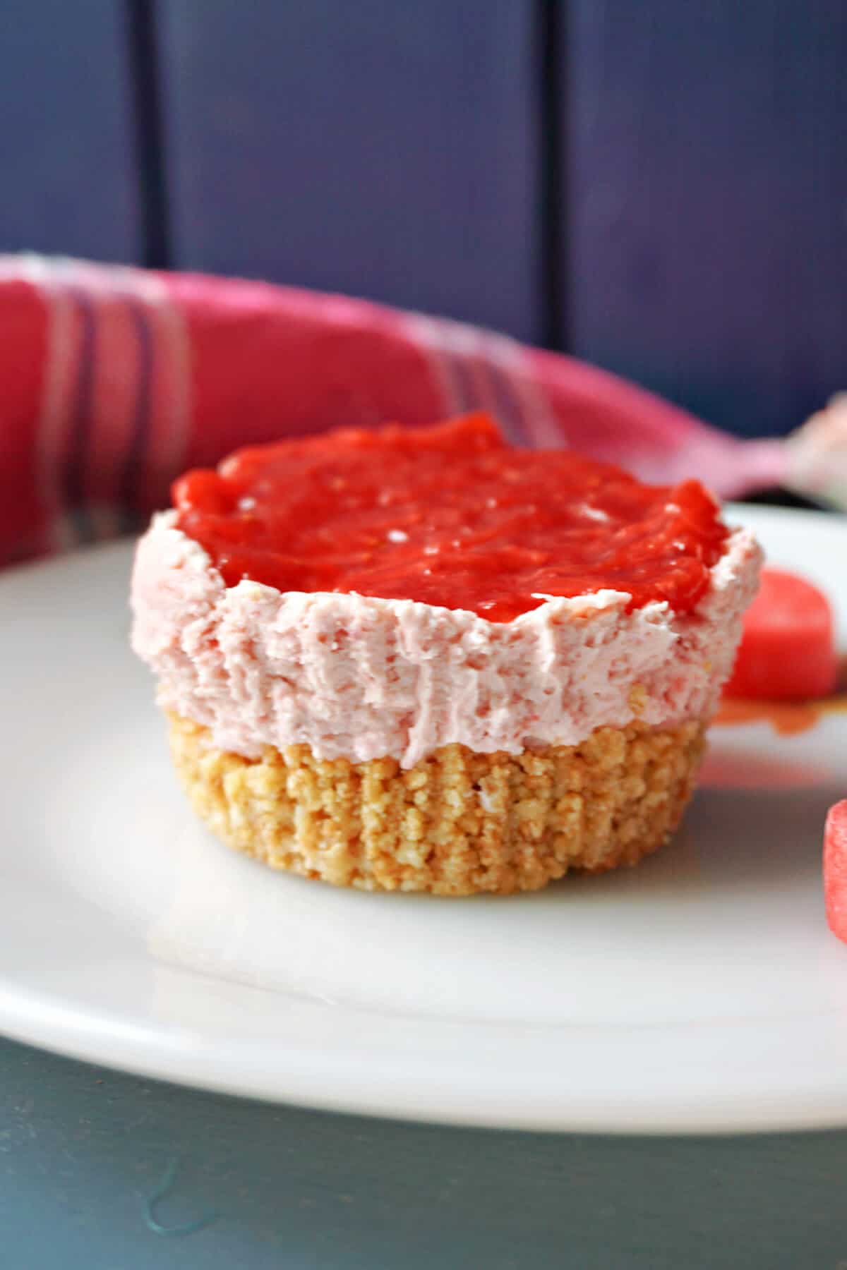 A white plate with a mini strawberry cheesecake and small love hearts around.