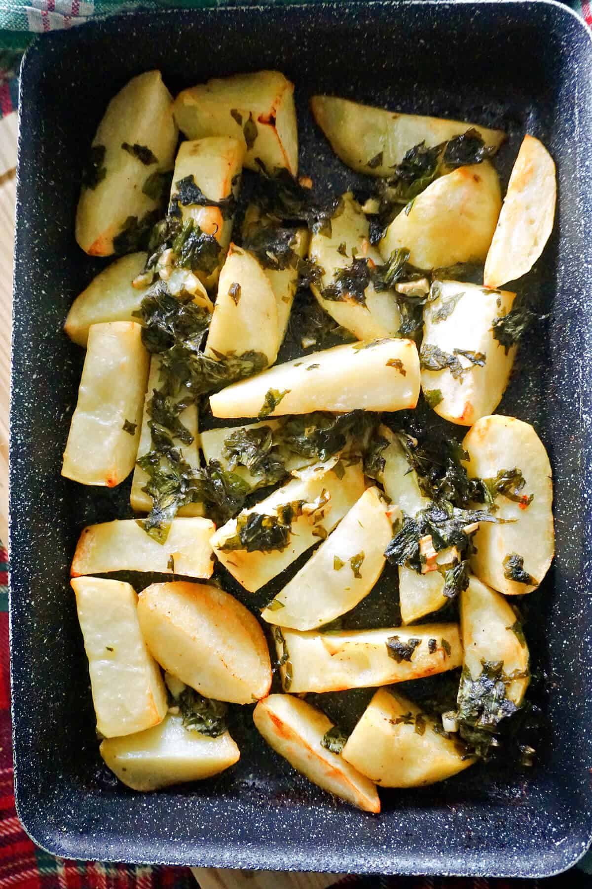 A tray with roasted potatoes topped with wild garlic.