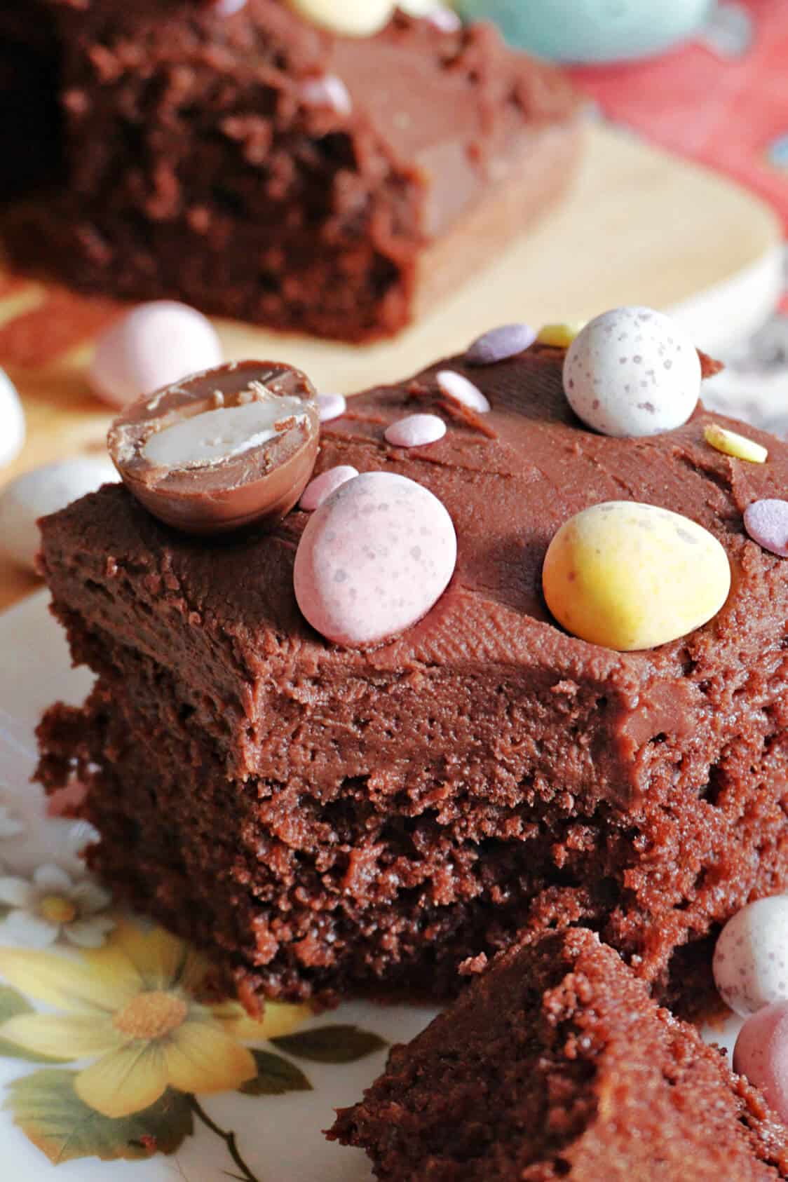 A slice of chocolate cake topped with Easter chocolate eggs.