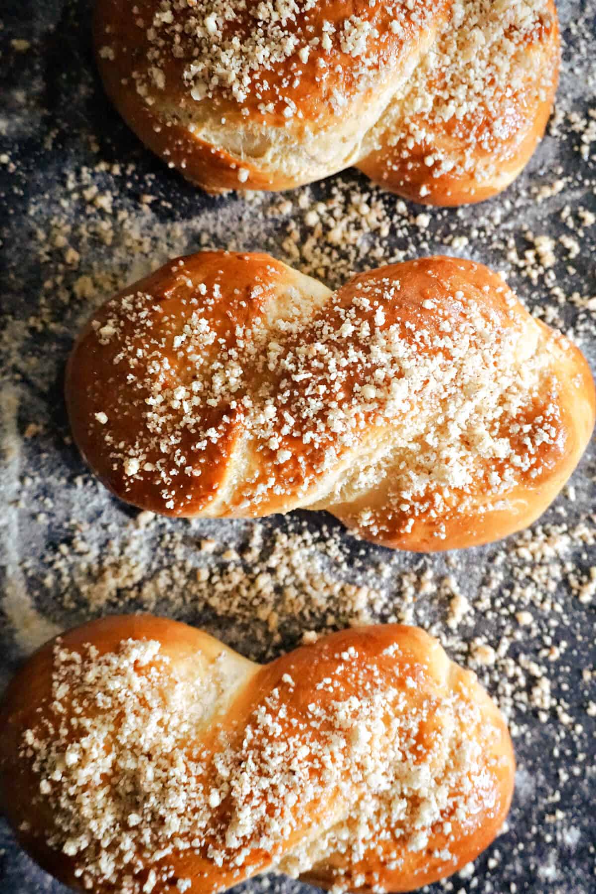 3 pasties topped with chopped walnuts on a baking tray.