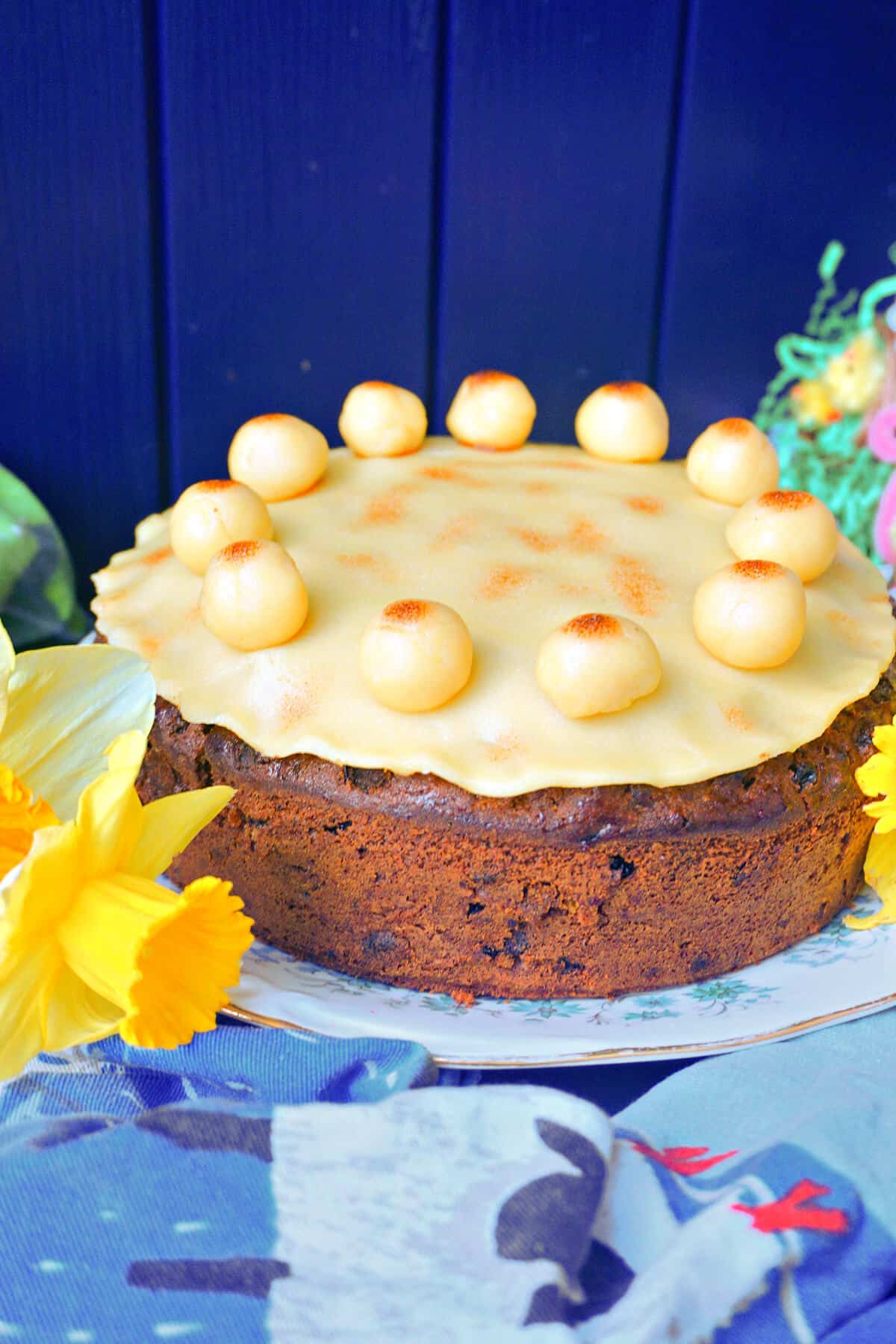 A simnel cake on a plate with Easter decor around.