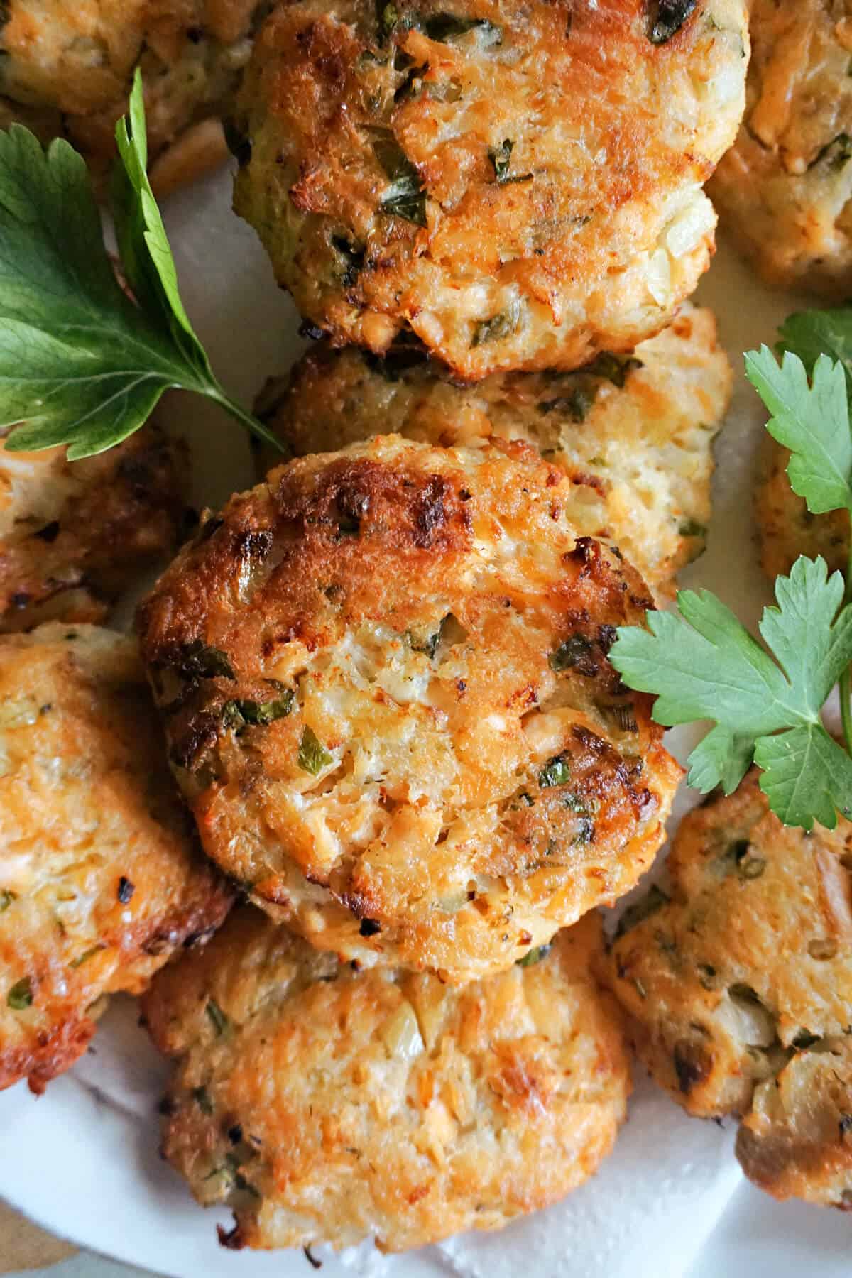 Salmon patties with fresh parsley leaves around.