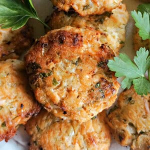 Salmon patties garnished with fresh parsley leaves.
