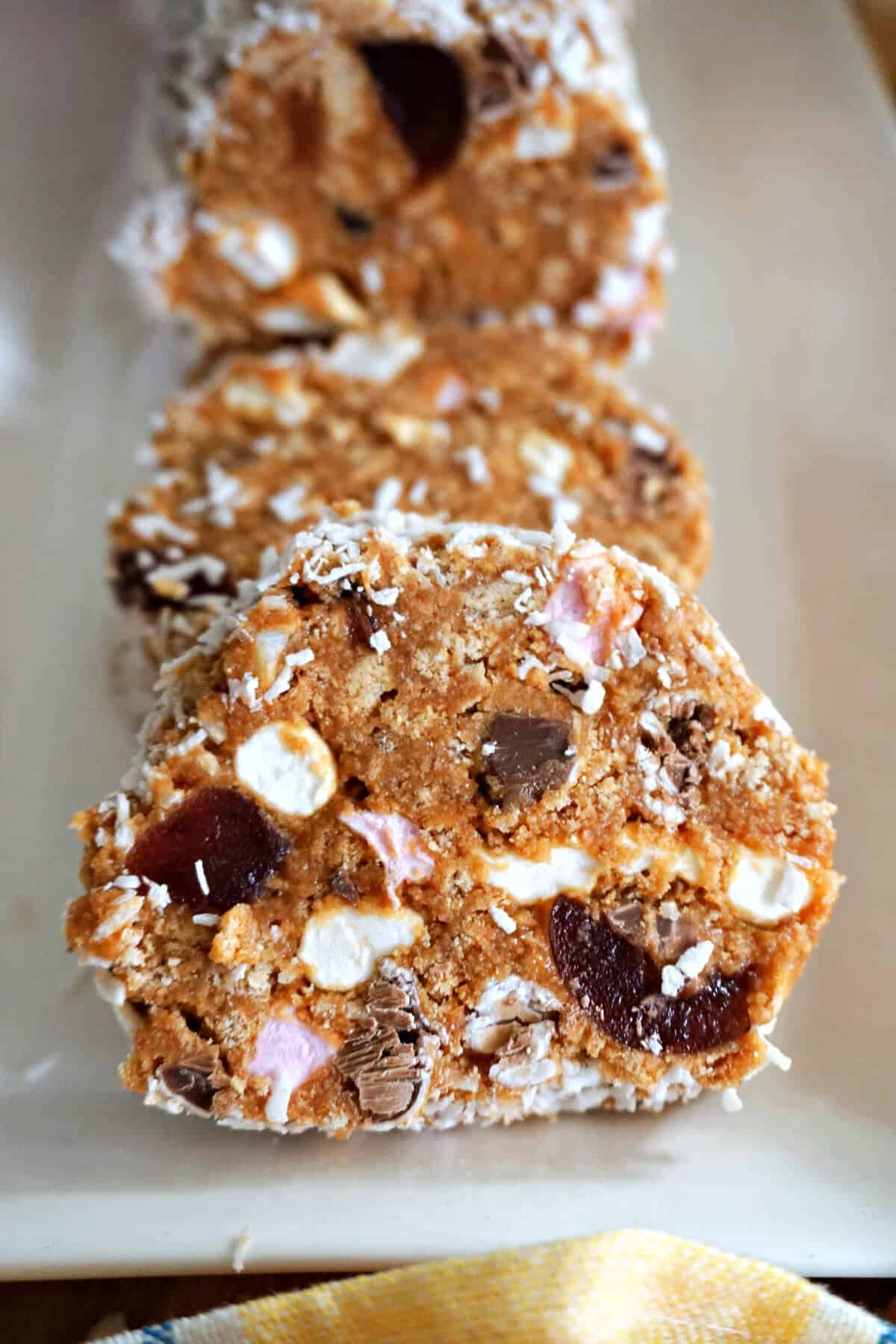 A white rectangle plate with 3 round slices of cake.