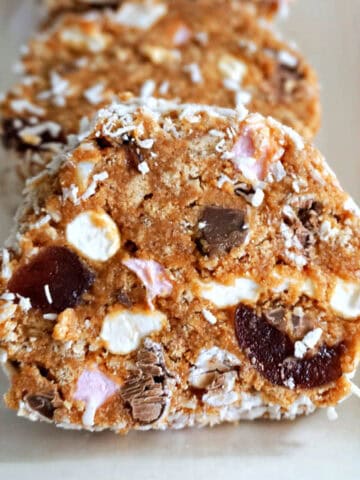 A white plate with 3 slices of cake.