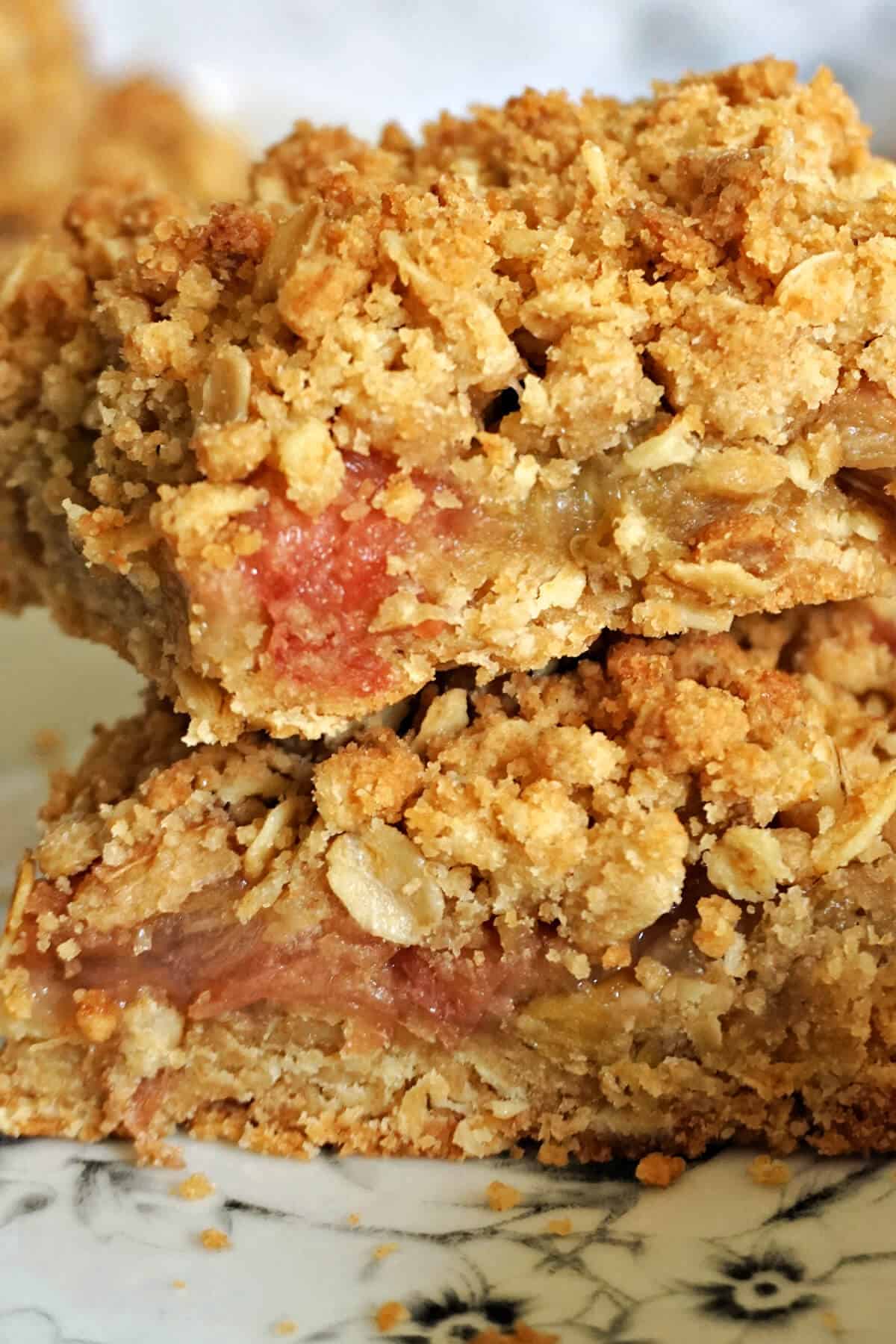 Close-up of 2 slices of rhubarb crumble bars piled up.