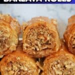 A white plate with baklava rolls.