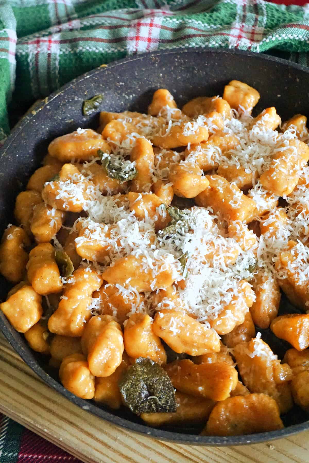 A pan with sweet potato gnocchi with grated parmesan on top.