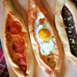 3 Turksih pide on a wooden board.
