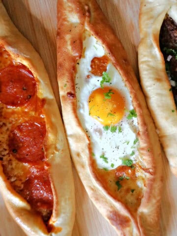 3 Turksih pide on a wooden board.