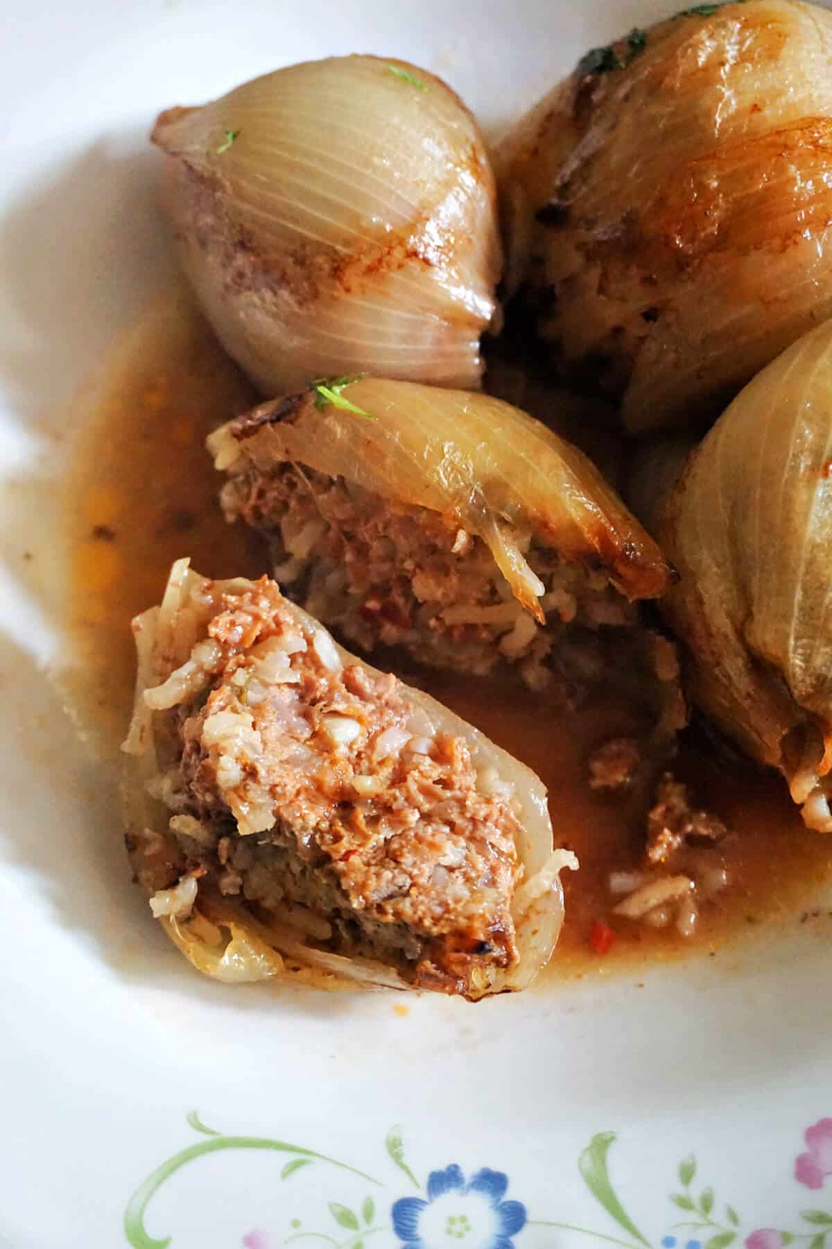A plate with stuffed onion and half an onion to show how the filling is inside.