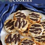 A white plate with chocolate-dipped cookies and a blue tea towel around it.