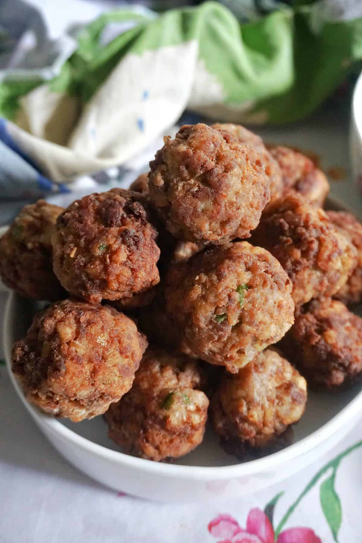 A white bowl with meatballs.
