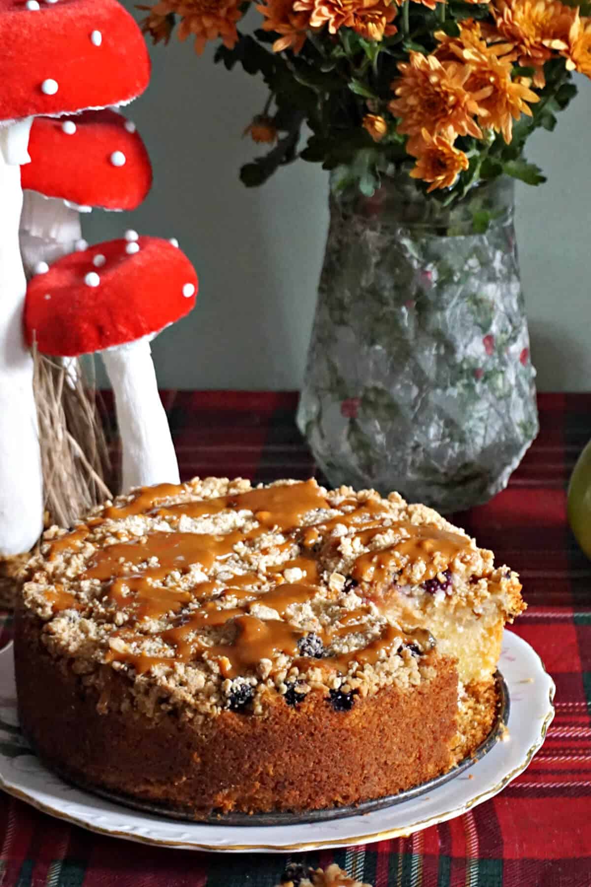 A cake on a white plate with autumnal decorations around.