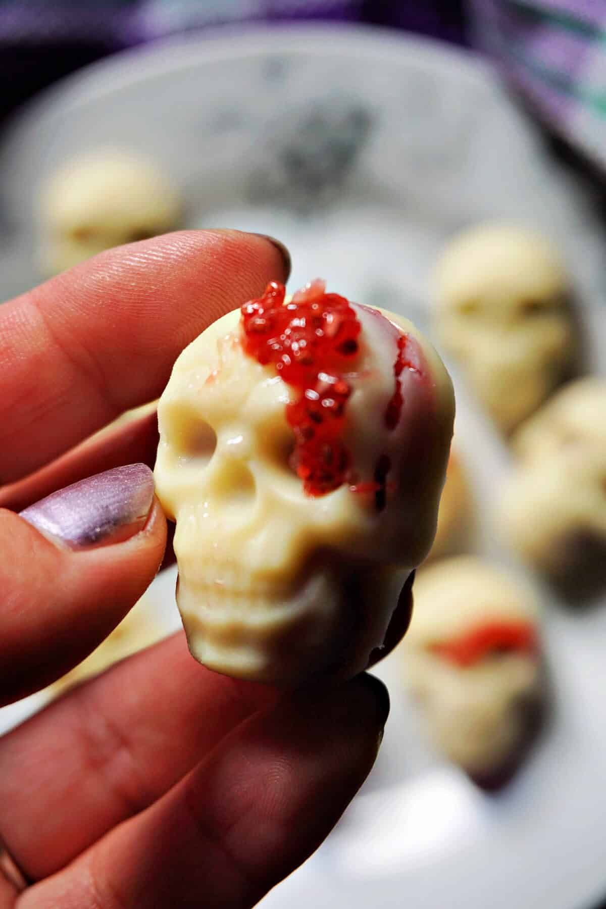 White chocolate skull with strawberry filling and red sprinkles for Halloween.